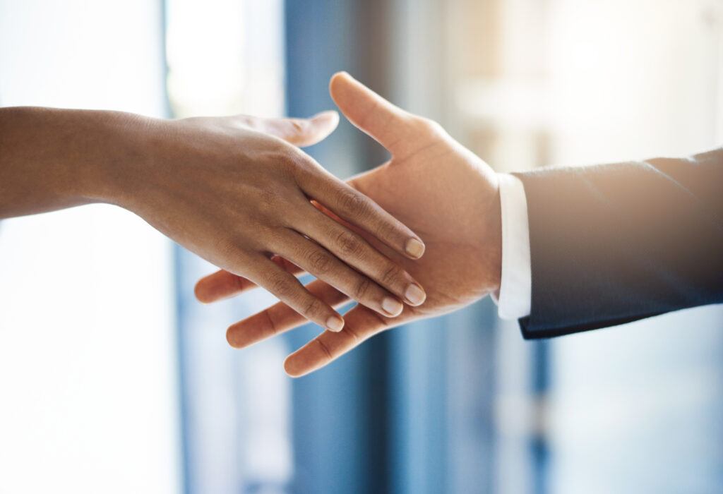 Office, handshake and deal for people, agreement and closeup of partnership in meeting or opportunity. Shaking hands, employee or gesture for client in business, congratulations or together for sales